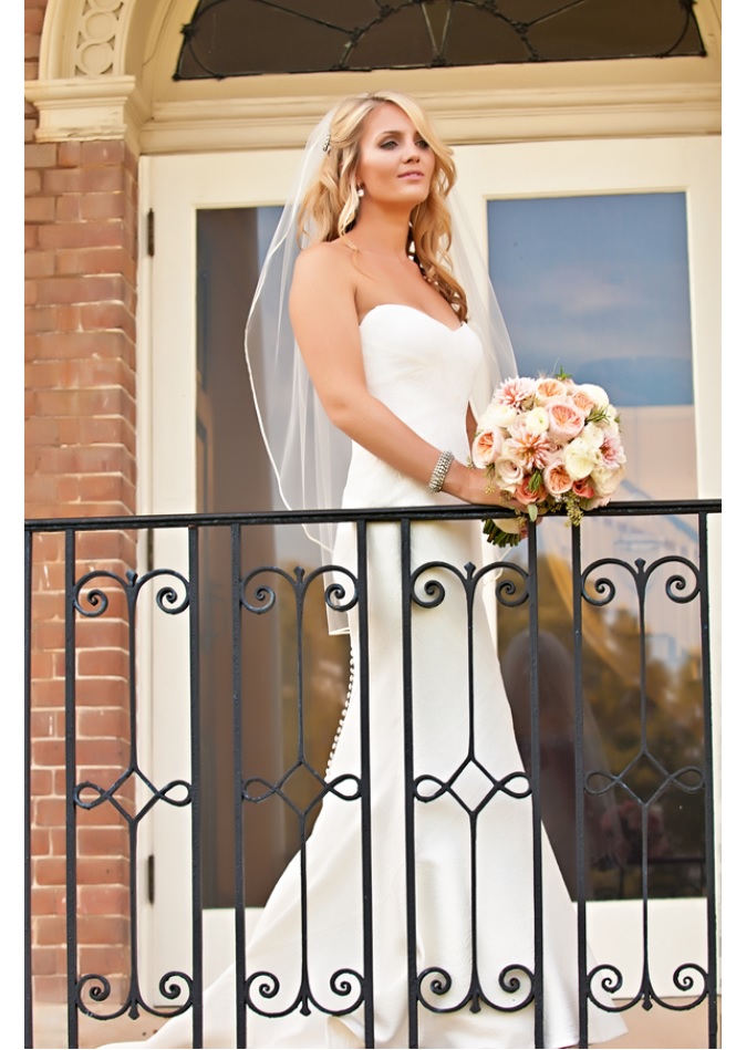 Bride in gown with bouquet on balcony